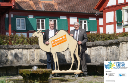 Bürgermeister von Markt Nordheim und Landrat mit dem "Maskottchen" der Energiekarawane, einem Kamel