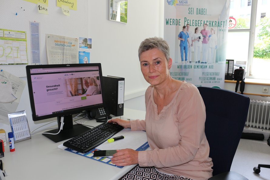 Heike Kühl sitzt am Computer mit NEA WiS auf dem Bildschirm