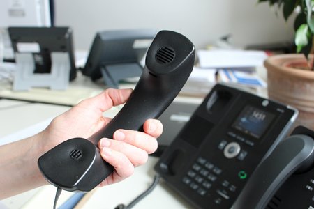 Telefon ein Telefonhörer wird von einem Telefonapparat im Landratsamt abgehoben