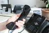 ein Telefonhörer wird von einem Telefonapparat im Landratsamt abgehoben