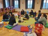 Mütter mit Kindern sitzen am Boden im Kreis