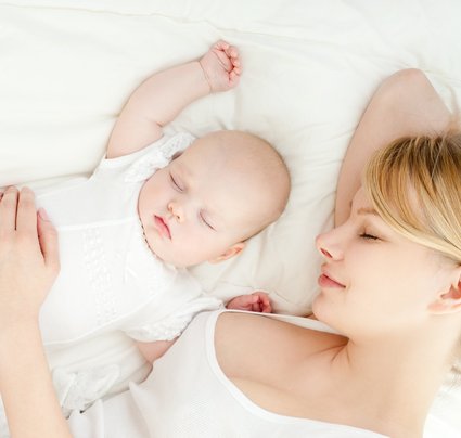 Mutter mit Baby Mutter liegt mit Baby auf dem Bett und schläft