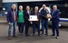 Personen vor Flugzeug mit Überreichung Defibrillator